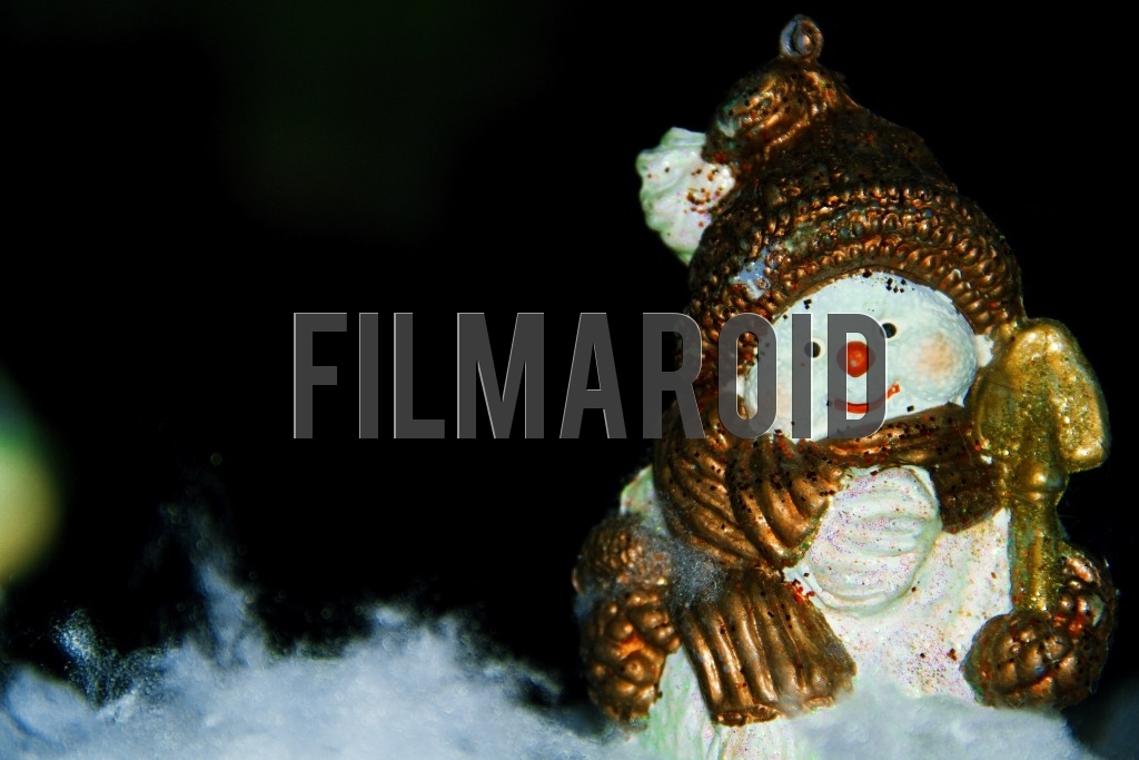 An ornate resin figure of a happy snowman set against a dark night background