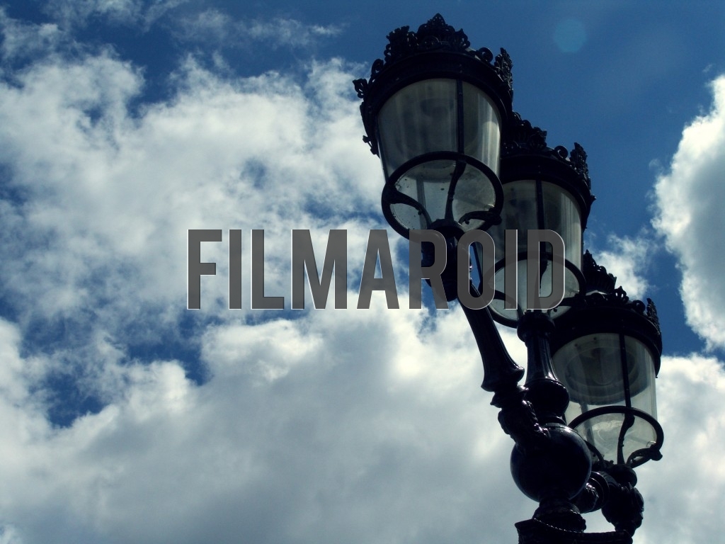 A set of beautiful Parisian lamps against a dramatic cloudy and sunny sky as background
