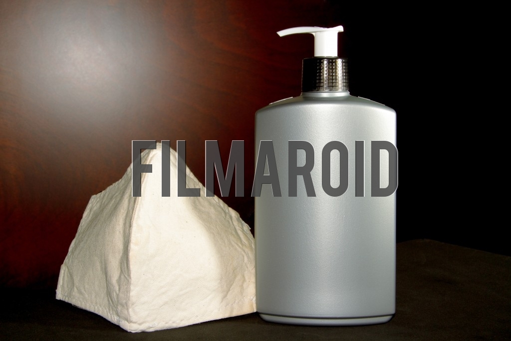 Isolated set of a face mask and a large plastic bottle with hands gel ideal for protecting against coronavirus and the covid19 pandemic